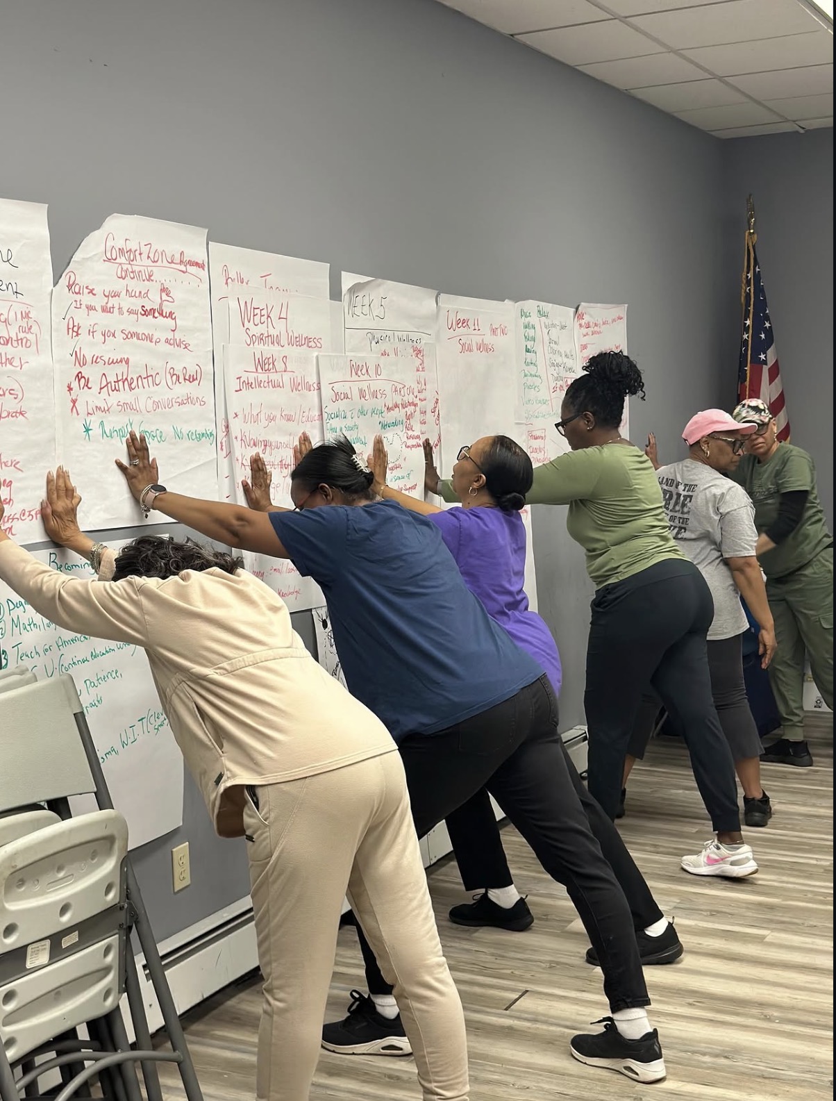 Group members stretching together while reviewing the weekly wellness curriculum