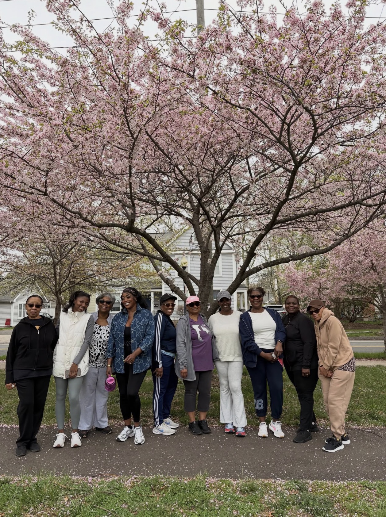Fit in Faith members on a fellowship walk together, smiling under blossoming trees