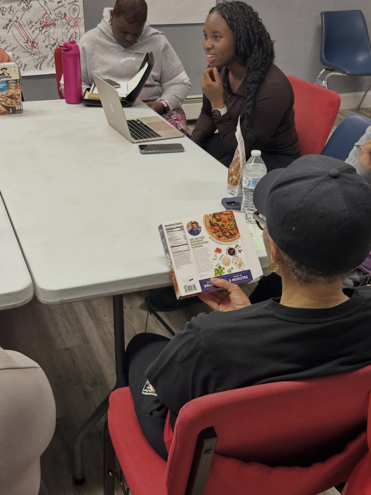 Two group members discussing a healthy meal option and reading its nutrition label